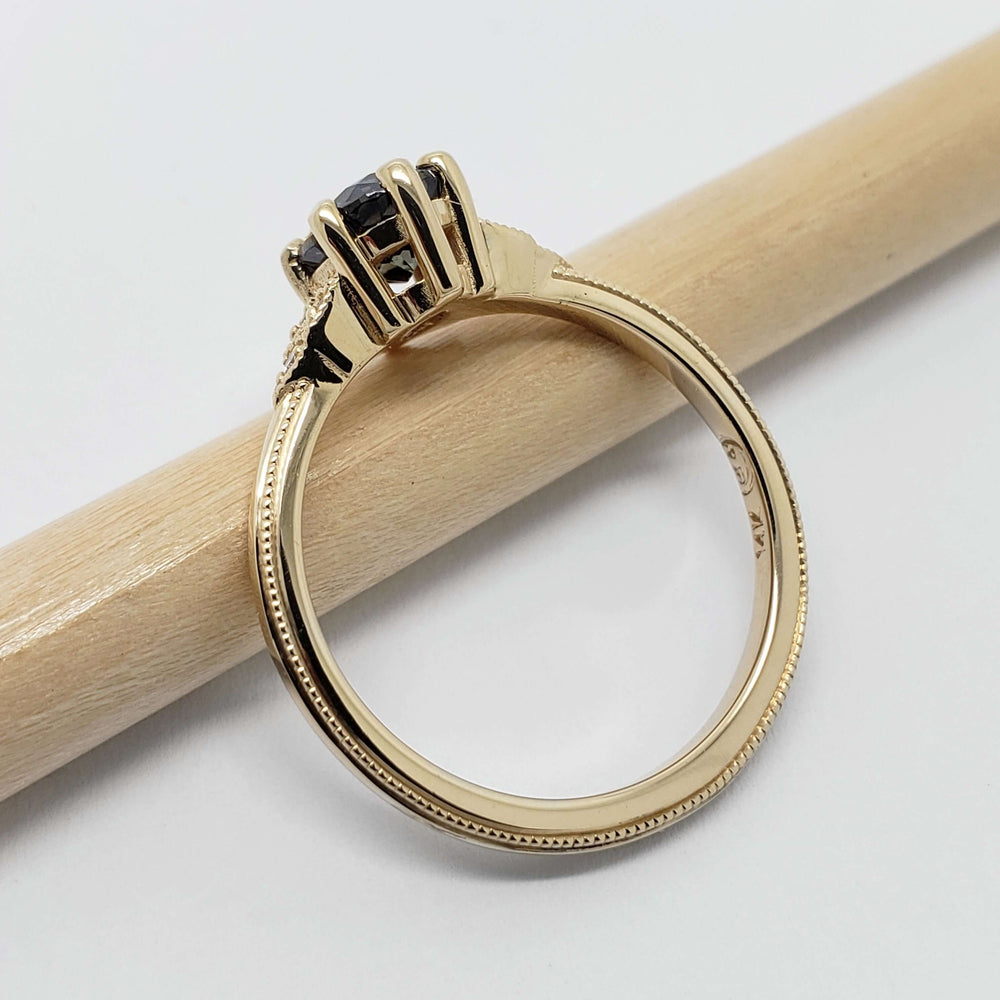 Side view of yellow gold engagement ring with purple sapphire and millgrain detail