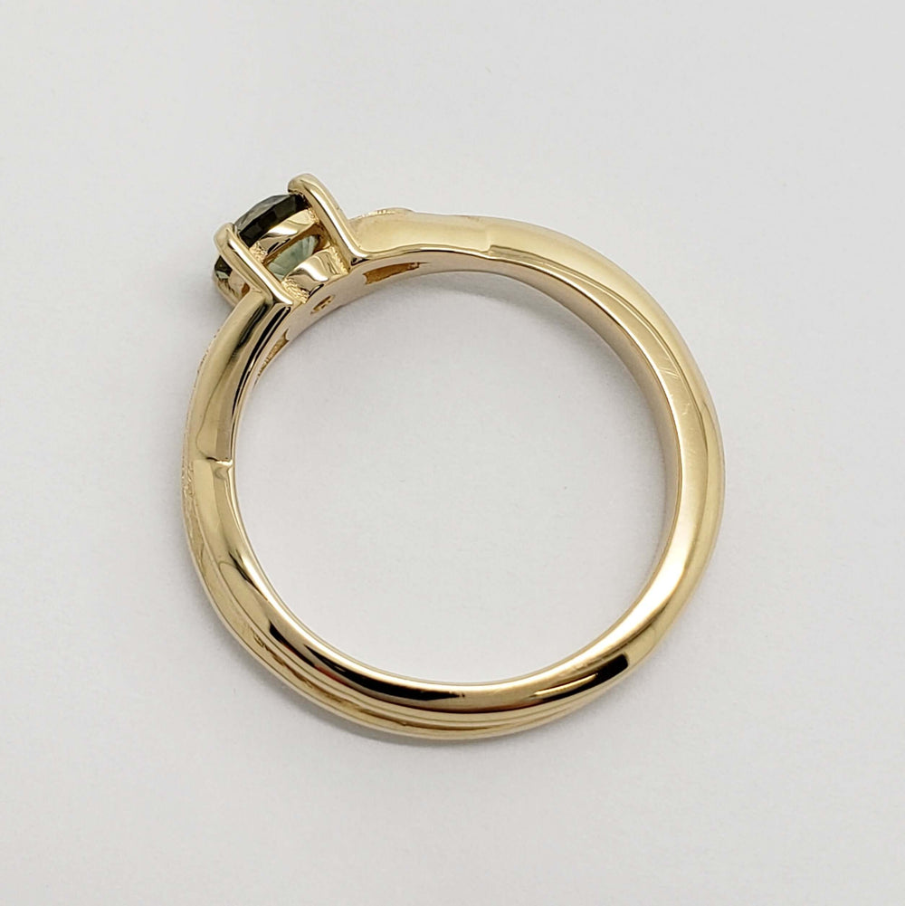 Side view of yellow gold ring showing sapphire setting and band