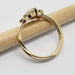 Side profile of 14kt yellow gold ring with diamond and sapphires on a pencil