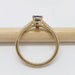 Side view of yellow gold ring with lavender sapphire and diamond accents on a pencil