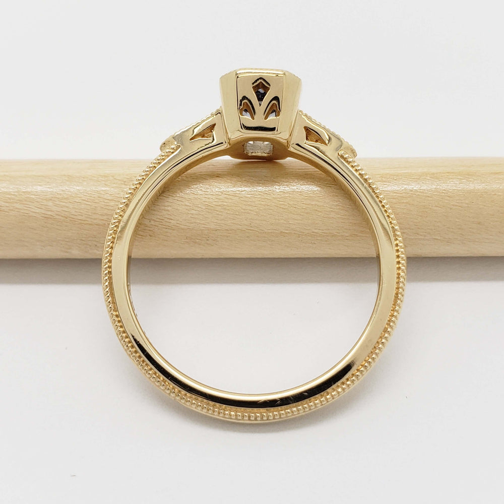Side view of yellow gold ring with milgrain detail and cutout setting, no stone visible
