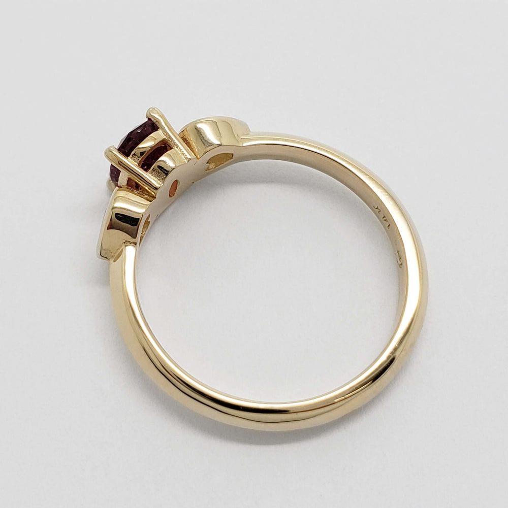 Side view of yellow gold ring with pink sapphire and heart-shaped lab diamonds