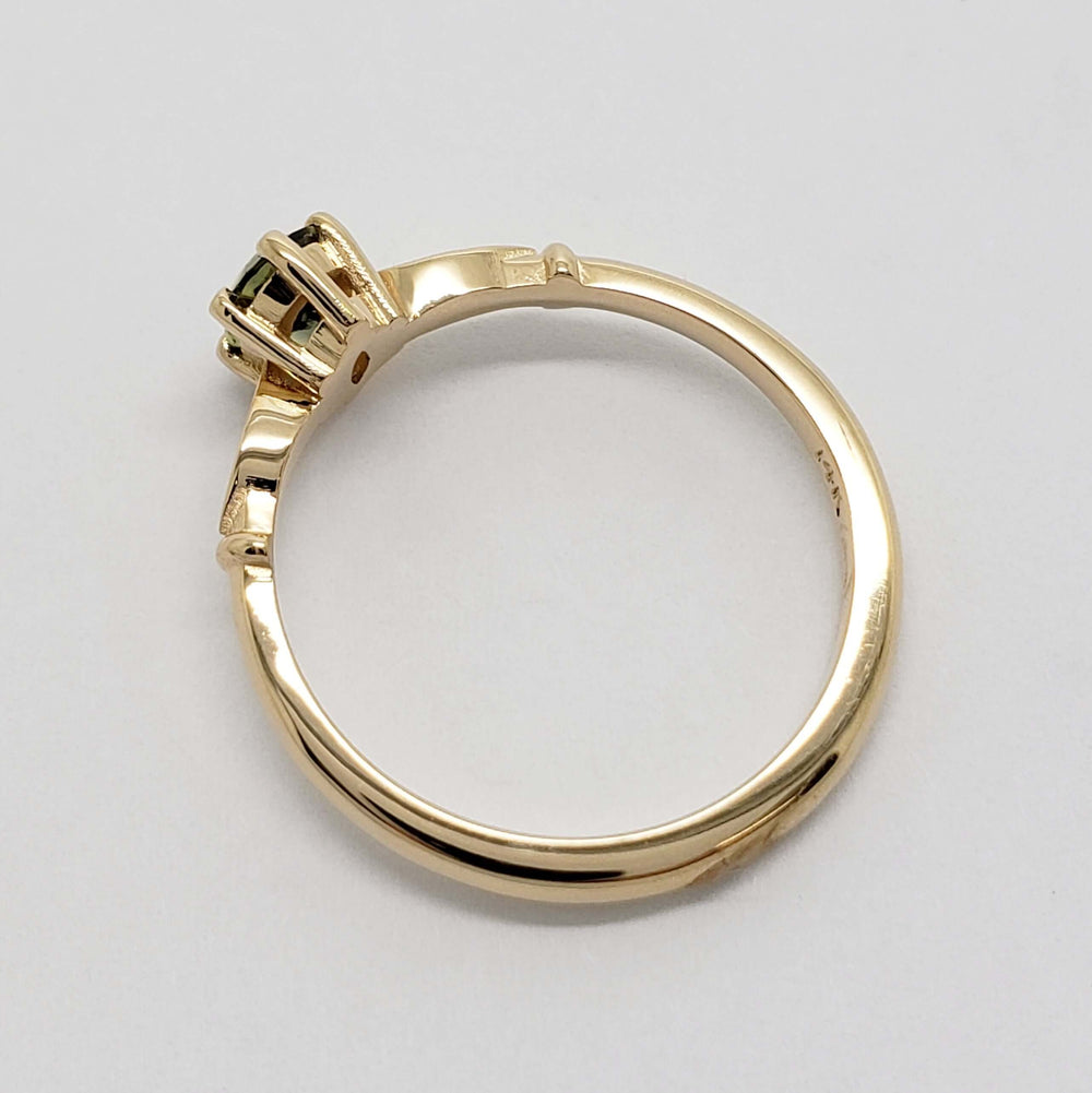 Side view of 14kt yellow gold ring showing sapphire setting and polished band