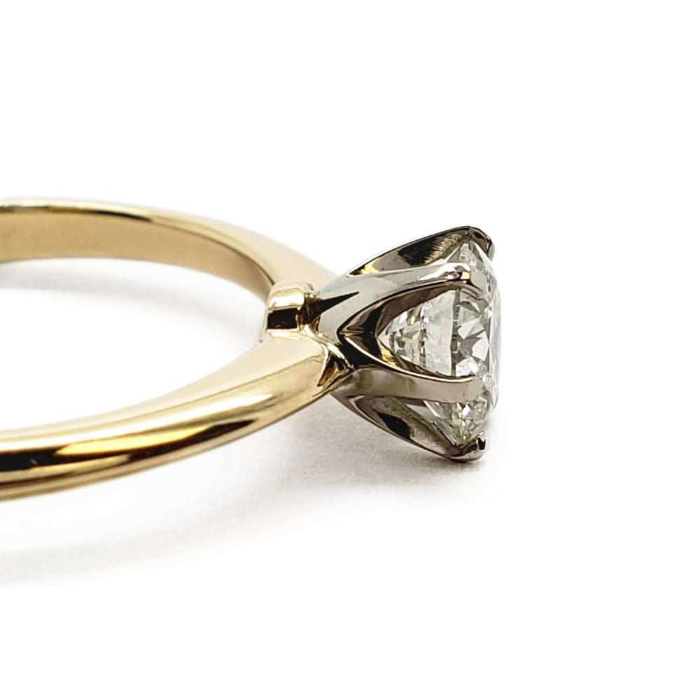 Side view of yellow gold ring with white gold six-prong setting and round diamond