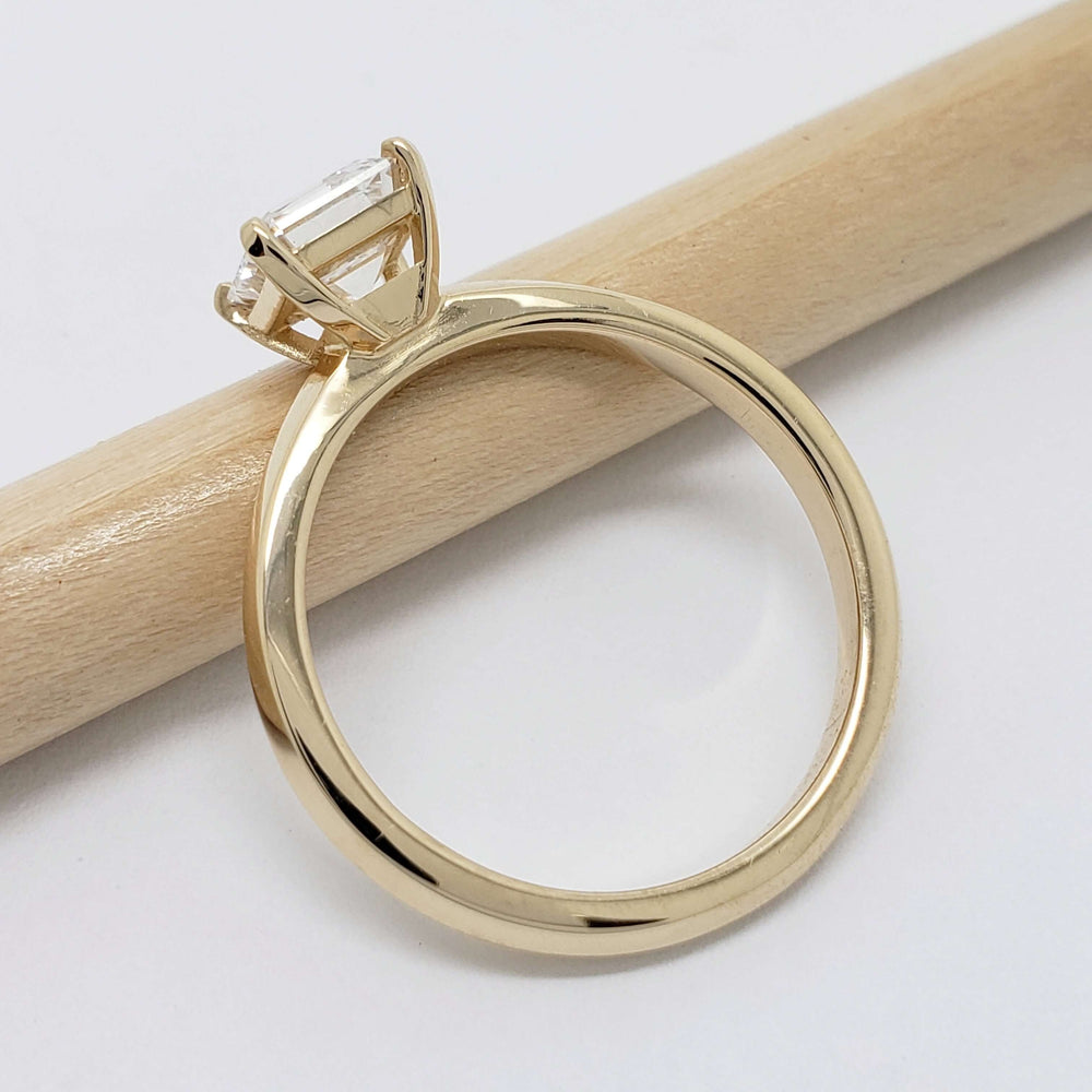 Side view of yellow gold solitaire ring with asscher cut lab diamond on pencil