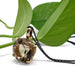 Smoky quartz and 14kt yellow gold pendant with black chain, styled with green leaves