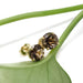 Smoky quartz and yellow gold stud earrings resting on a green leaf