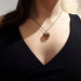 Smoky quartz pendant in 14kt yellow gold worn on a model with black chain