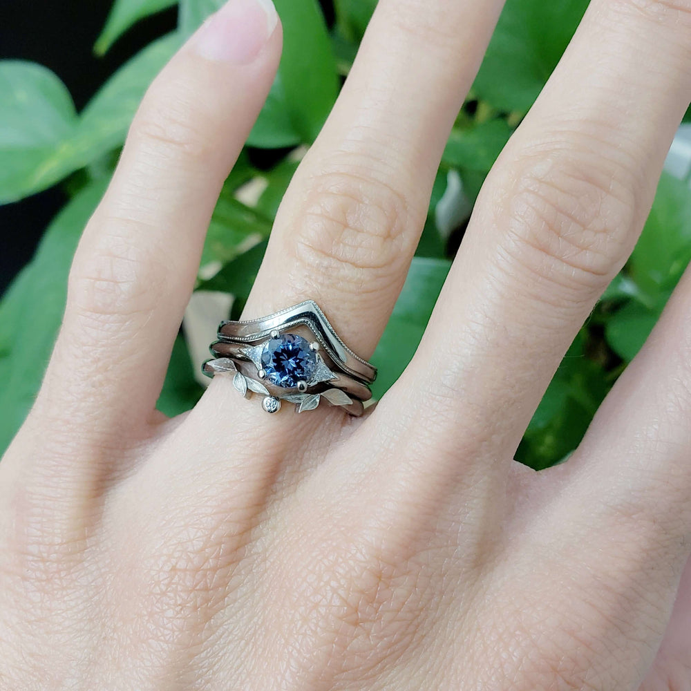 Spinel and diamond engagement ring stacked with two white gold bands on a hand