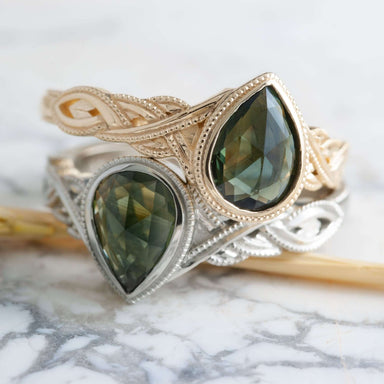 Stacked green sapphire engagement rings in white and yellow gold with intricate interlace bands