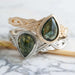 Stacked green sapphire engagement rings in white and yellow gold with intricate interlace bands