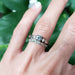 Stacked white gold floral wedding ring and diamond engagement ring on finger