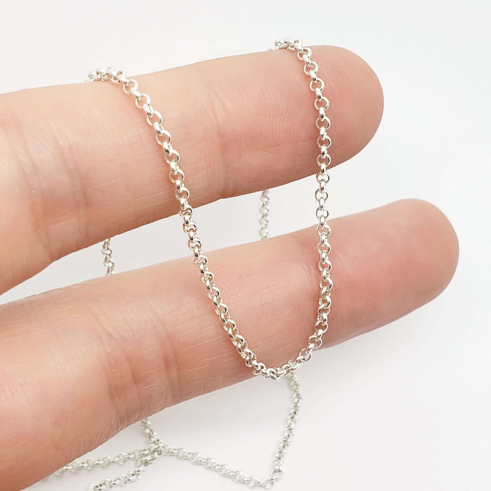 Sterling silver rolo chain necklace draped over fingers