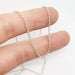 Sterling silver rolo chain necklace draped over fingers