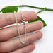 Sterling silver wheat chain bracelet held in hand with clasp visible