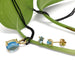 Swiss blue topaz pendant and matching stud earrings in 14kt yellow gold with plant background