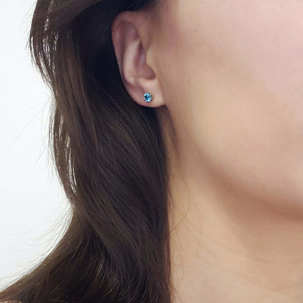 Swiss blue topaz stud earring worn on ear