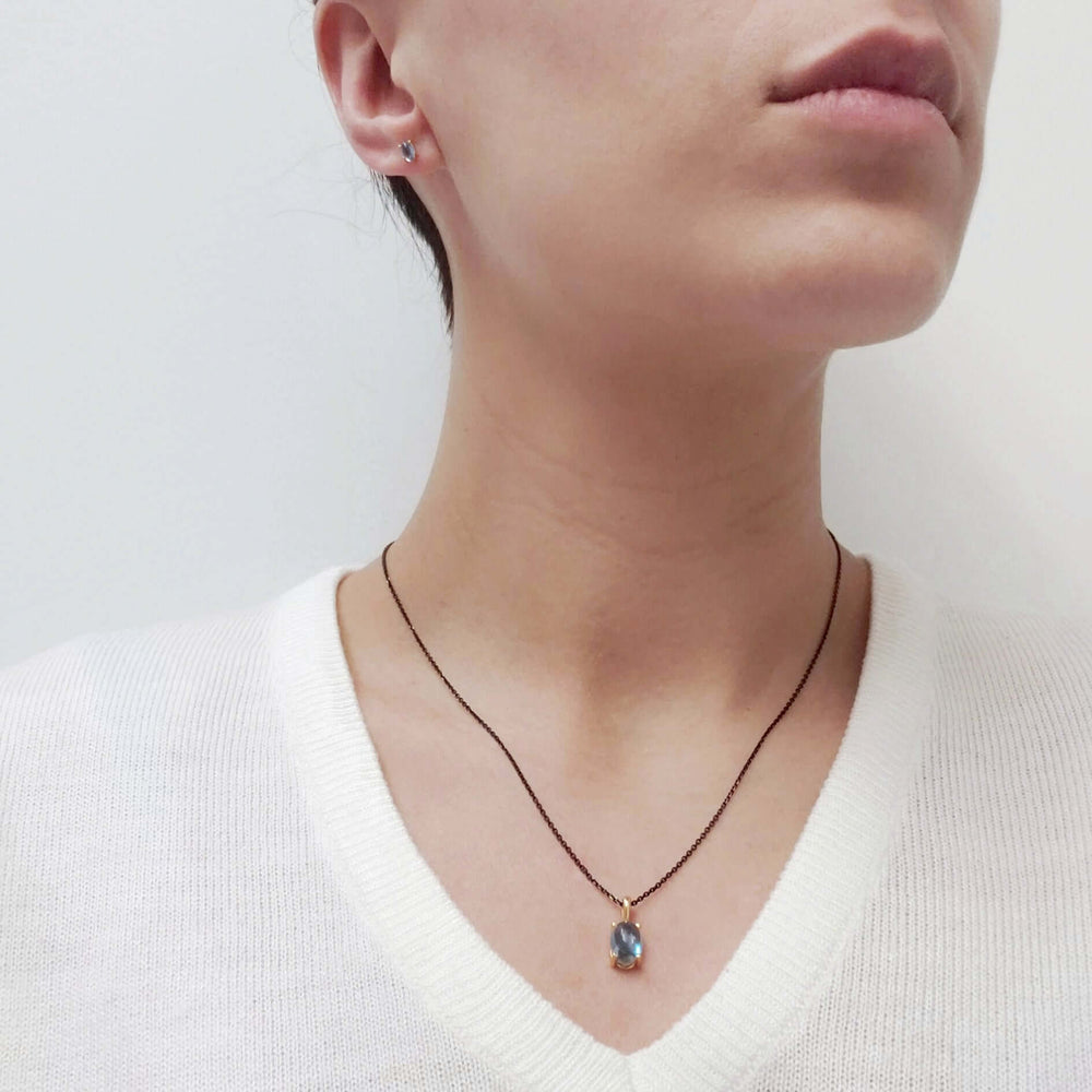 Model wearing Swiss blue topaz stud earrings and matching pendant necklace