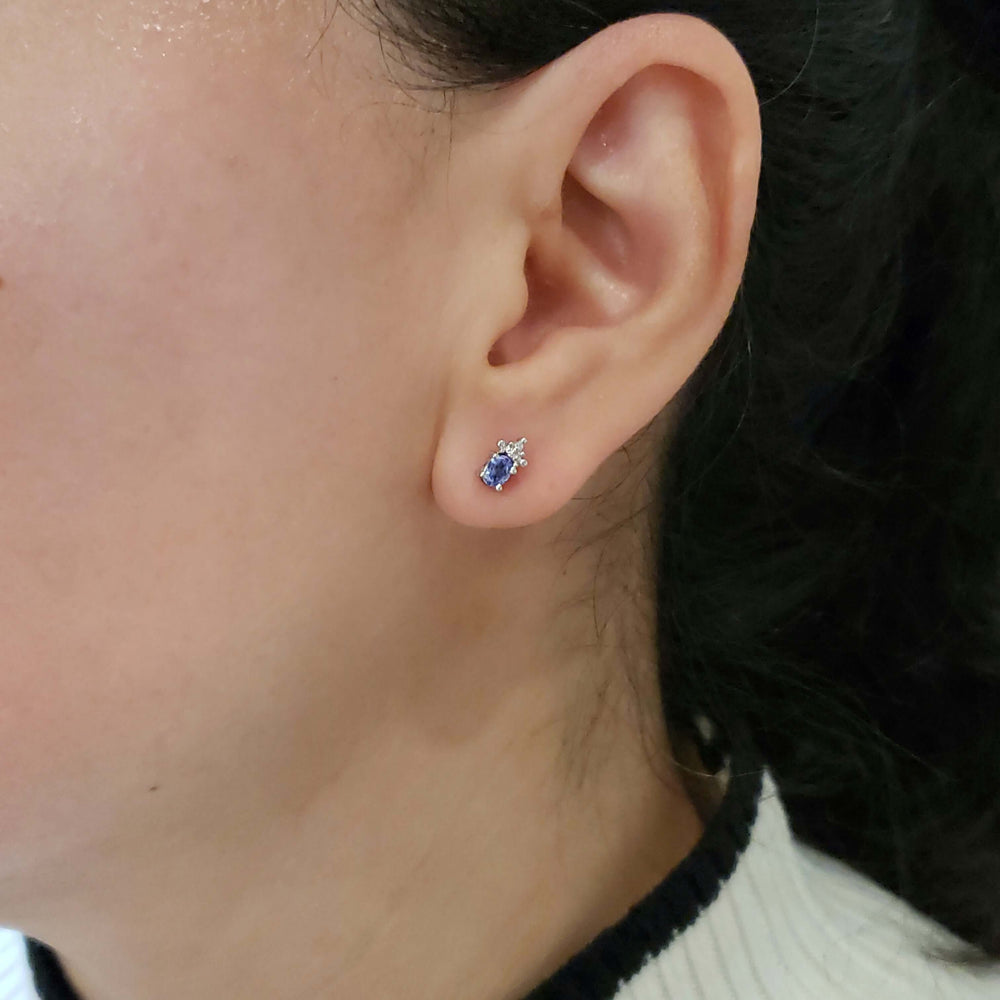 Tanzanite and diamond 10kt white gold stud earring worn on ear