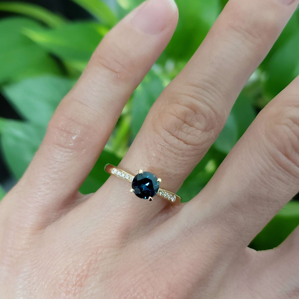 Teal Australian sapphire and diamond yellow gold ring shown on hand