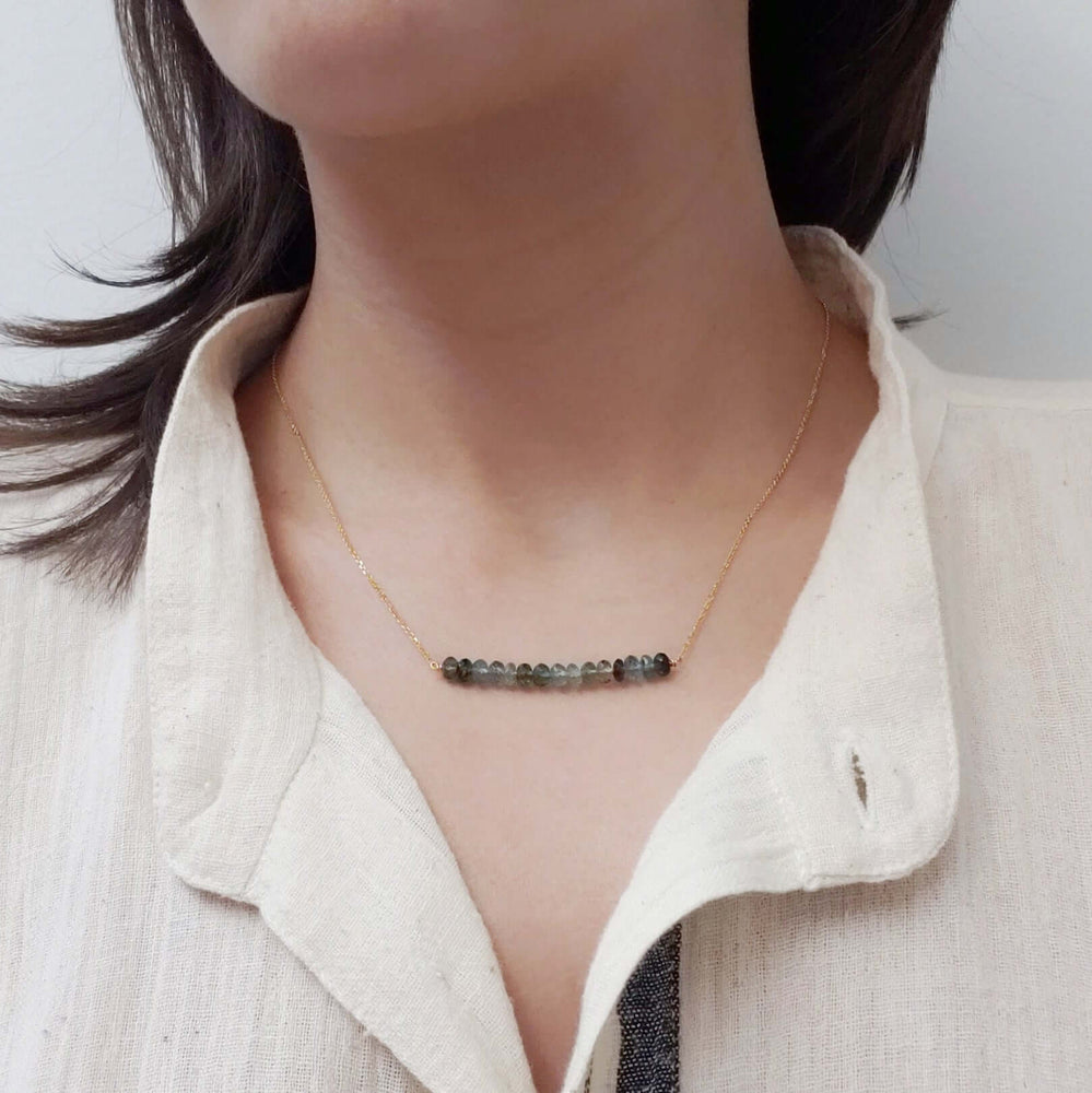 Teal tourmaline bead bar necklace in 14kt yellow gold worn on a model