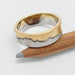 Textured 14k white and yellow gold mountain range ring displayed on a pencil
