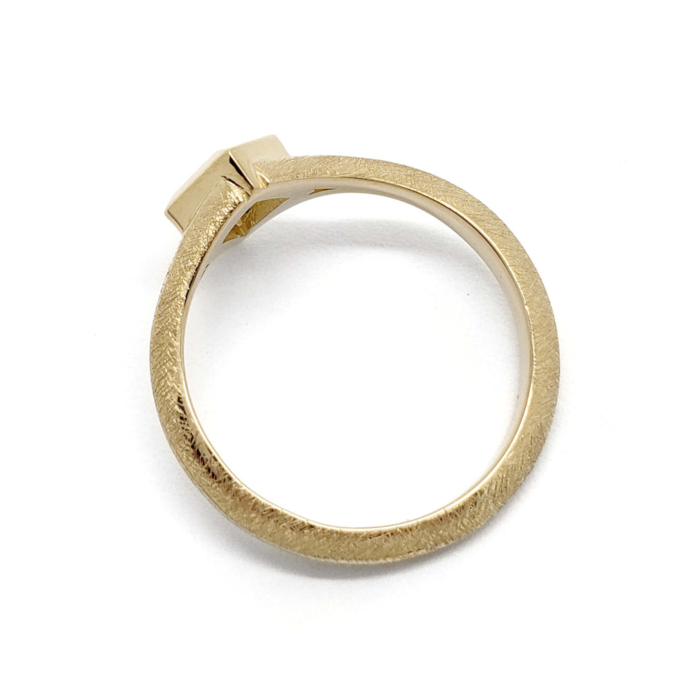 Side view of textured 14kt yellow gold ring band with bezel-set sapphire