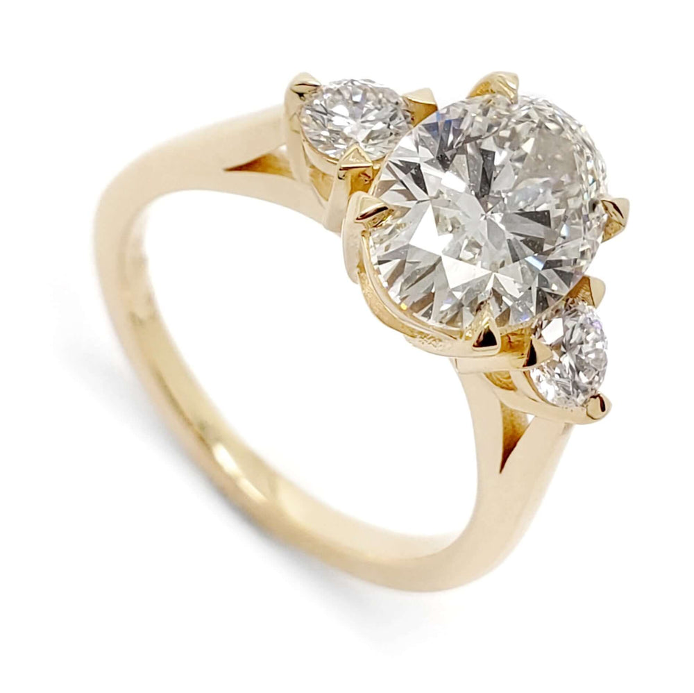 Three-stone engagement ring in 14kt yellow gold with oval lab-grown diamond and two round lab diamonds