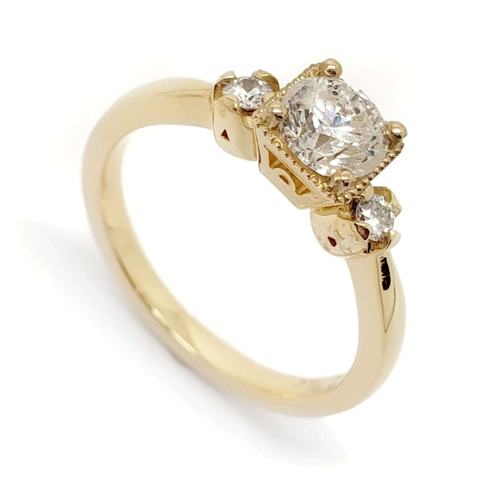Three-stone engagement ring in 14kt yellow gold with vintage round diamonds, angled view