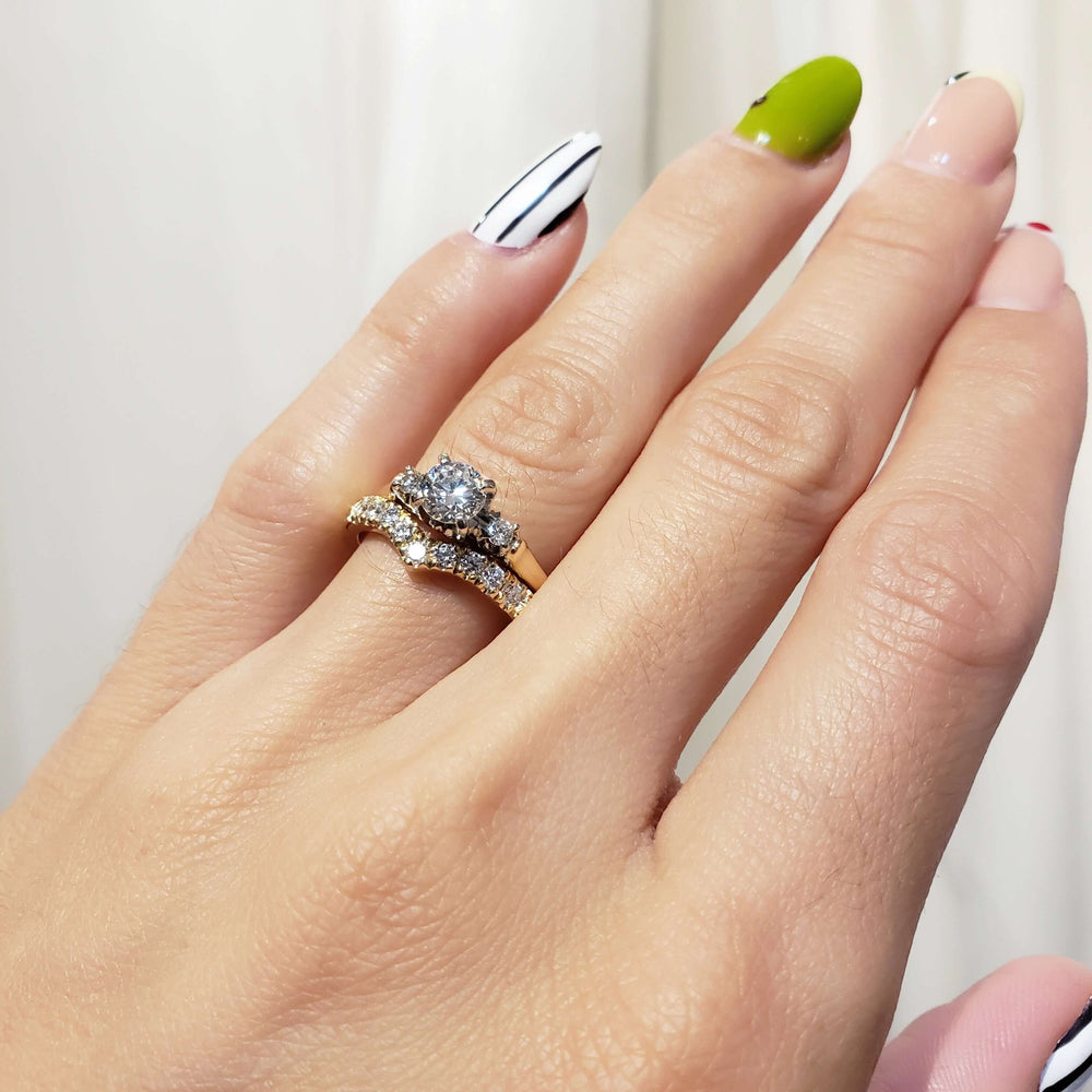 Three-stone vintage diamond ring paired with pave wedding band, both worn on hand