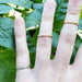 Three millgrain gold rings in yellow, white, and rose gold on fingers