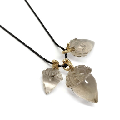 Three smoky quartz acorn pendants with 14kt yellow gold bails on blackened silver chains