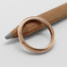 Top view of 14kt rose gold millgrain wedding ring on a pencil