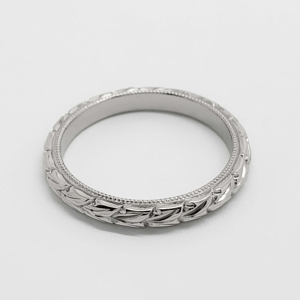 Top view of 14kt white gold wedding ring with wheat engraving and millgrain edge