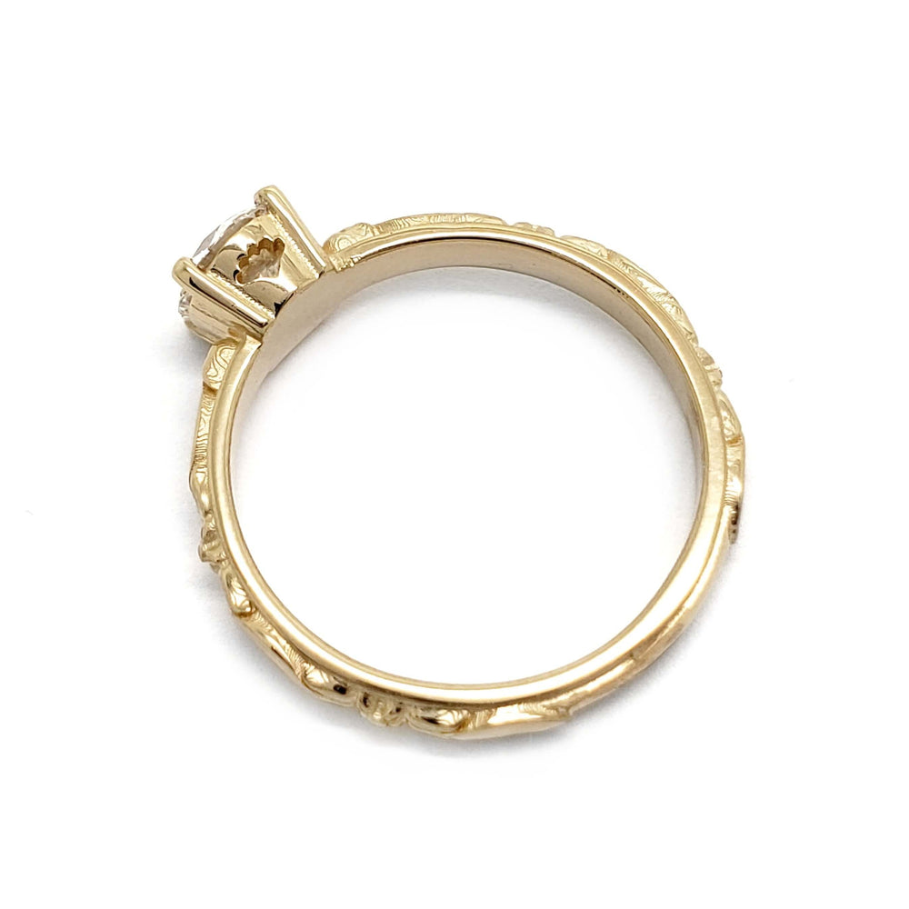 Top view of 14kt yellow gold ring with detailed band and round lab diamond