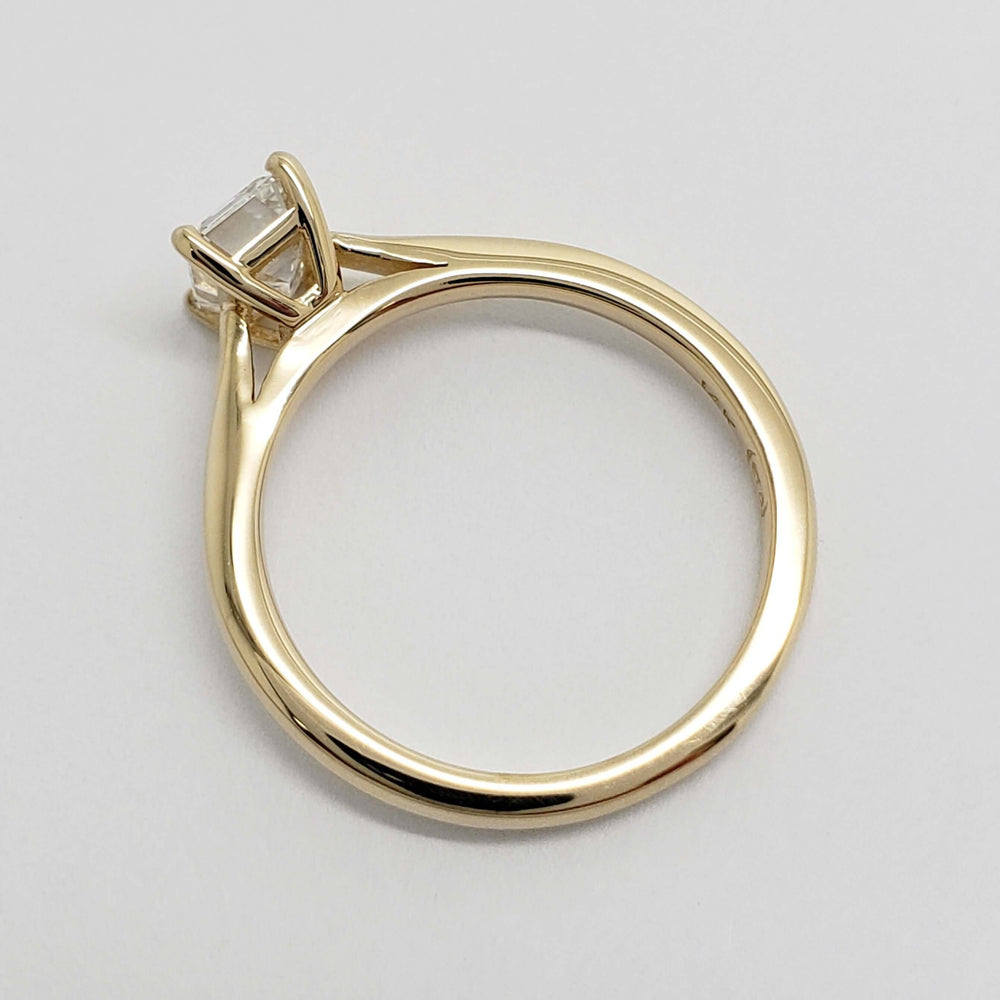 Overhead view of 14kt yellow gold solitaire ring with emerald cut lab diamond