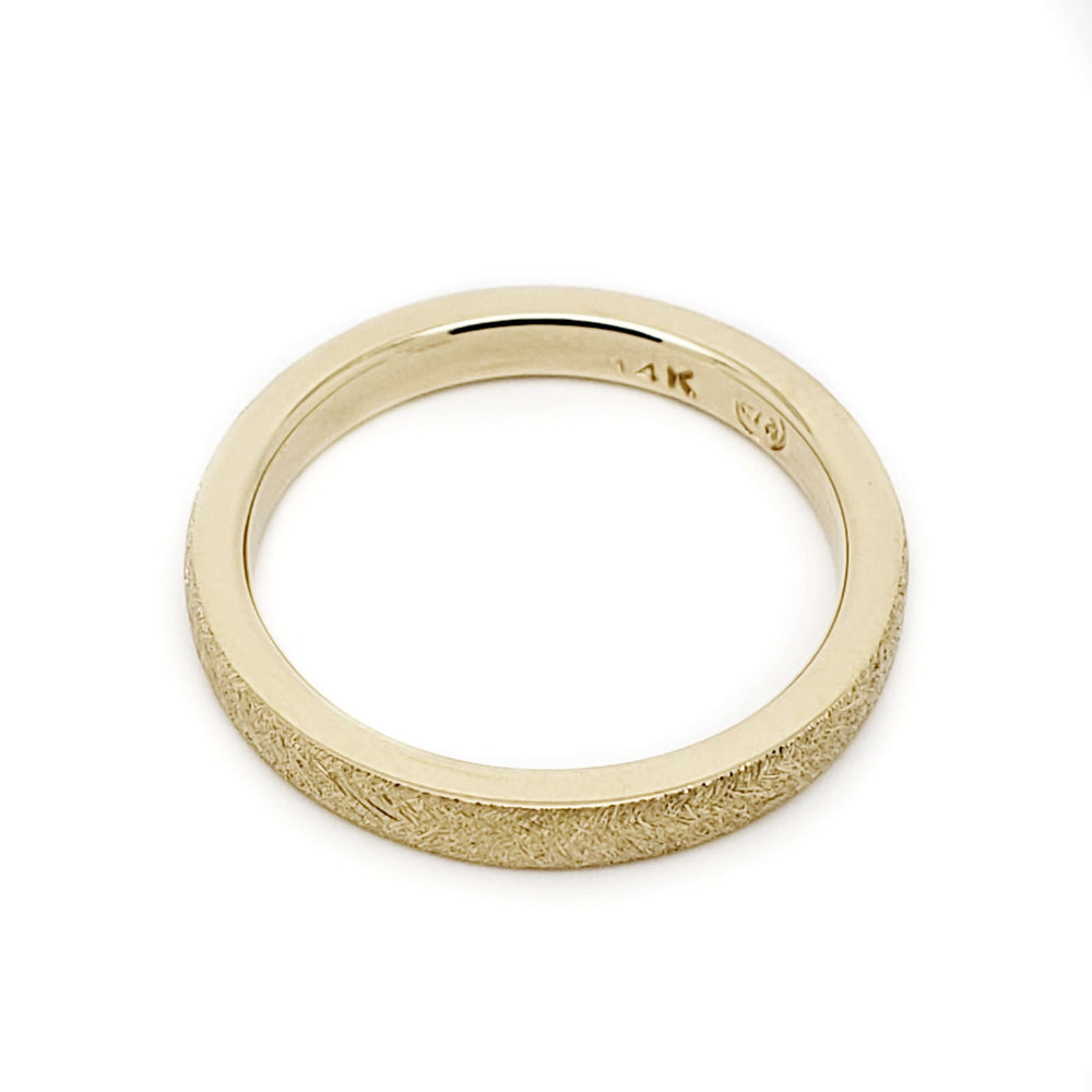 Top view of 14kt yellow gold wedding band with saw blade texture