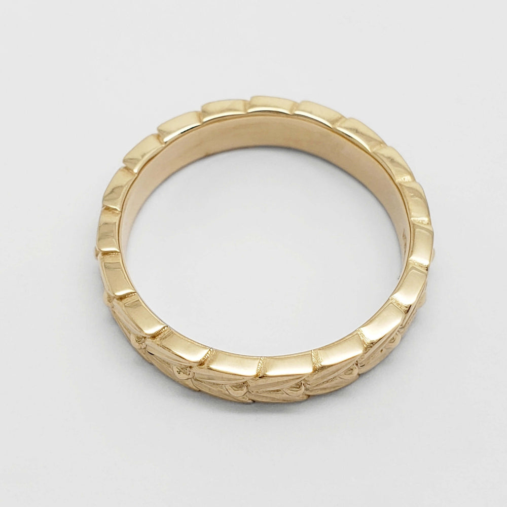 Top view of 14kt yellow gold wedding ring with hand engraved leaf pattern