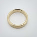 Top view of flat brushed 14k yellow gold wedding ring on white background