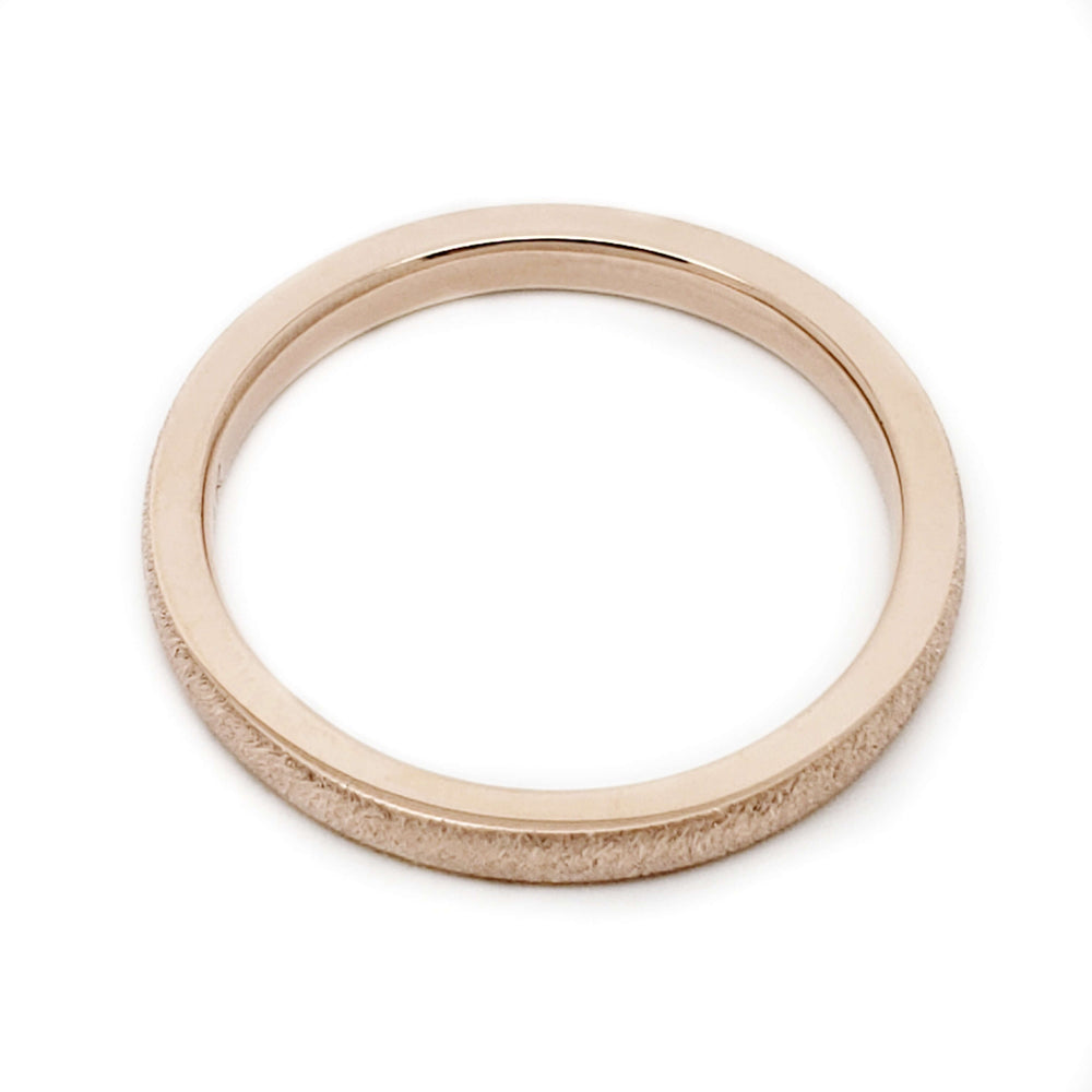 Top view of handcrafted rose gold wedding band with textured finish