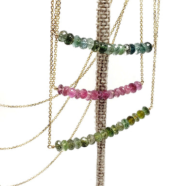 Tourmaline bead bar necklaces in teal, pink, and green on a display stand