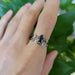 Trinity ring stacked with engraved white gold band, worn on finger