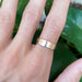 Two tone 14k white and rose gold mountain range ring shown on a hand
