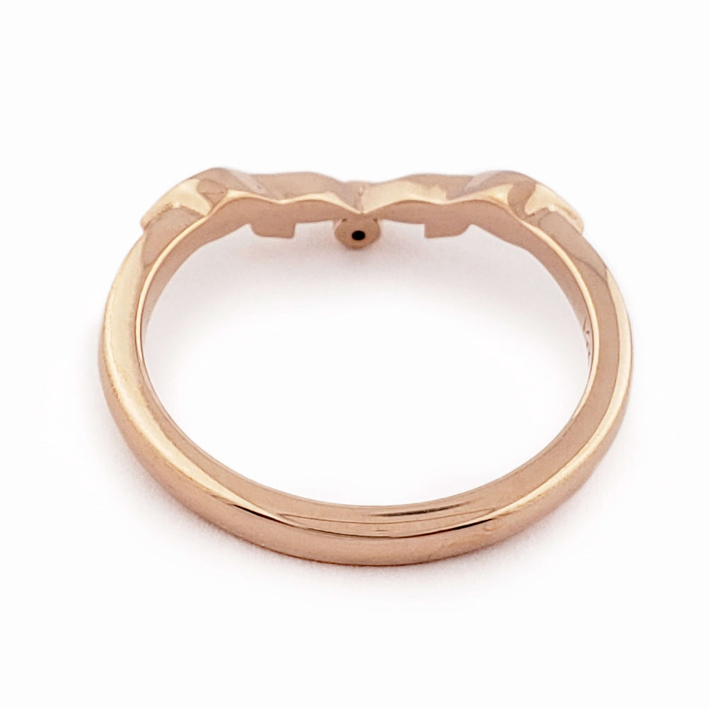 Underside of 14k rose gold leafy wedding ring with bezel-set diamond