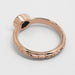 Underside of 14kt rose gold engraved ring with milgrain detail and teal sapphire
