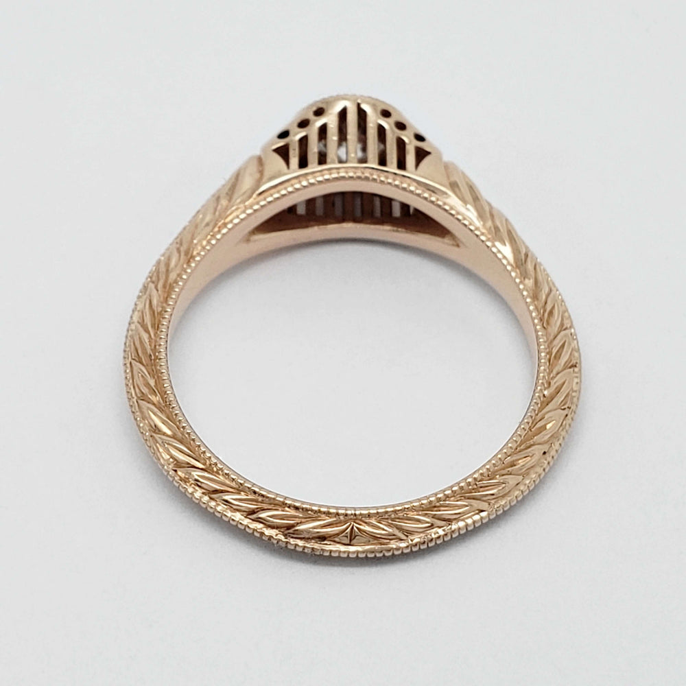 Underside view of 14k rose gold ring showing engraved band and filigree gallery