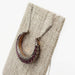 Victorian ruby and diamond crescent pendant necklace displayed on a linen stand.