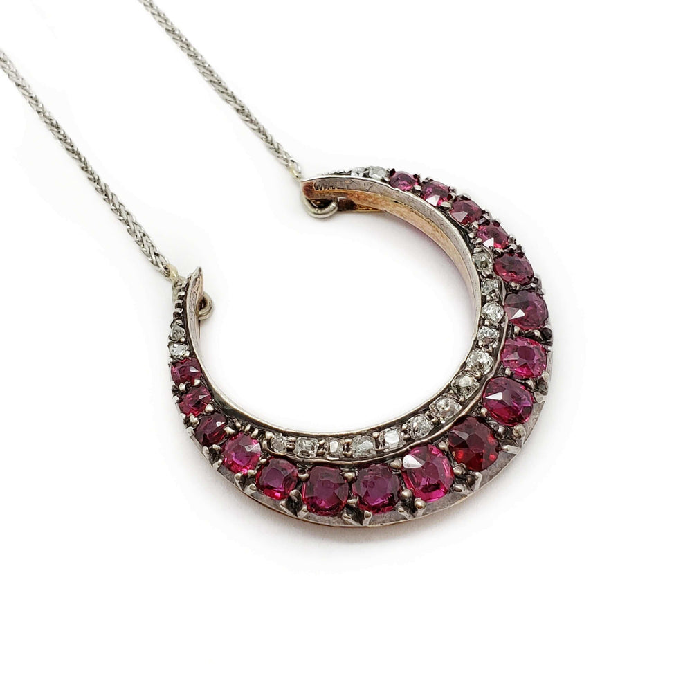 Victorian crescent pendant necklace with cushion cut rubies and diamonds on a white gold chain.