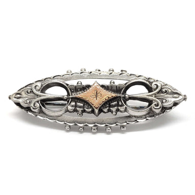 Victorian two-tone silver and rose gold pin with ornate scrollwork and engraved detail