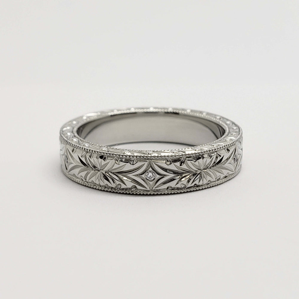 Vintage-style 14kt white gold wedding band with engraved floral pattern and diamonds